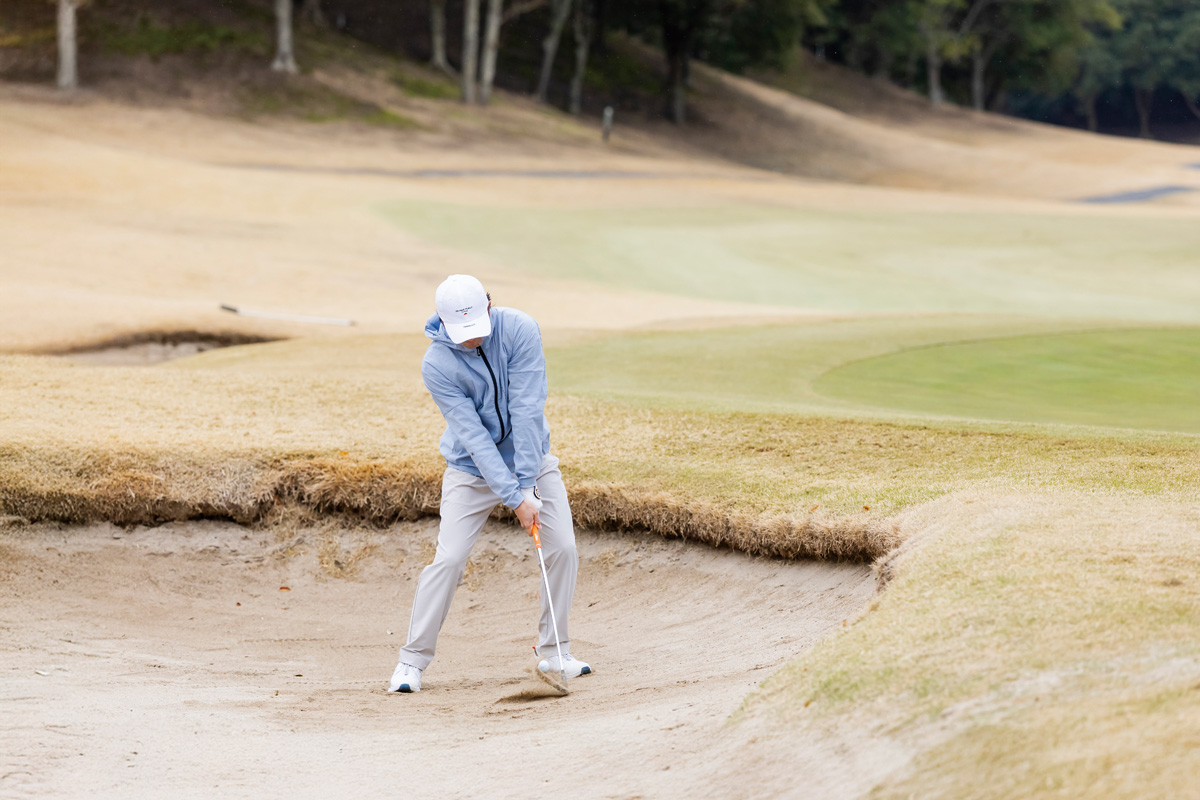 ボールポジションはスイングの支点である左鎖骨下にセット。ヘッドの最下点はボール3センチをイメージしたい。